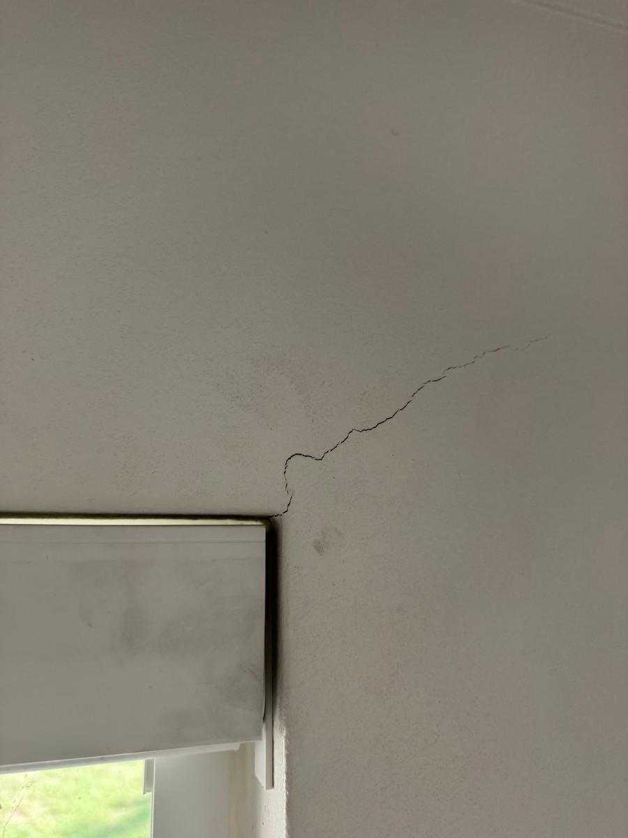 Drywall crack running up from the corner of a window